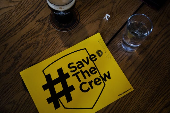 A modified Save The Crew poster sits on a table before an announcement regarding the purchase of the Columbus Crew SC Major League Soccer team by Cleveland Browns owner Jimmy Haslam and a local Columbus partner on Friday, October 12, 2018 at Endeavor Brewing Company in Grandview Heights, Ohio. [Joshua A. Bickel/Dispatch]