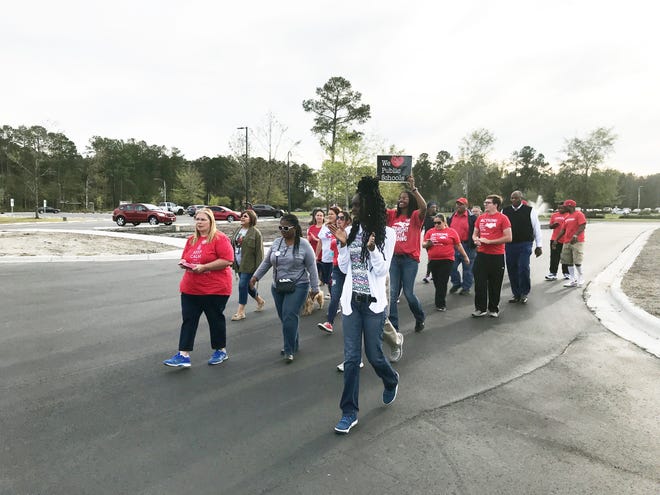 Teachers march on the polls with chants like "Let's go vote" and "Red for ed" on Tuesday, Oct. 23, 2018. [Maxim Tamarov/The Daily News]
