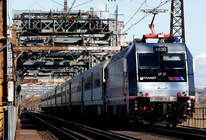 FILE - In this Friday, Nov. 14, 2014 file photo, a New Jersey Transit train travels across a portal bridge in Kearny, N.J. [AP Photo/Julio Cortez]