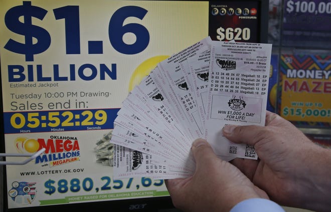 A customer, who did not want to be identified, displays the $200 worth of Mega Millions tickets he bought at Downtown Plaza convenience store in Oklahoma City on Tuesday. [AP Photo/Sue Ogrocki]