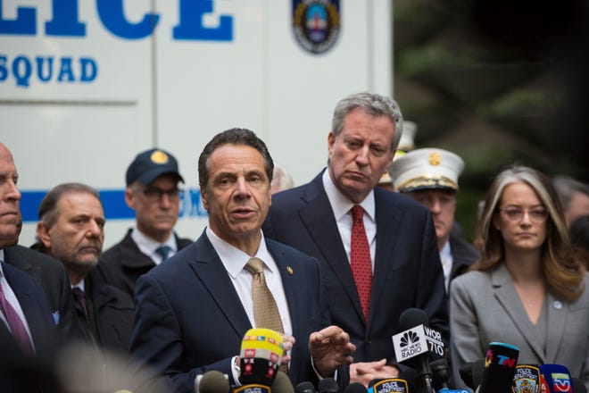 Mayor Bill de Blasio looks on as Gov. Andrew Cuomo delivers remarks during a news conference after NYPD personnel removed an explosive device from Time Warner Center Wednesday in New York. The U.S. Secret Service says agents intercepted packages containing "possible explosive devices" addressed to former President Barack Obama and Hillary Clinton and other Democratic politicians. [Kevin Hagen/The Associated Press]