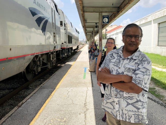 In this Aug. 9, 2018 photo, Jishnu Mukdrji and Penny Jacobs wait to board an Amtrak train in Orlando, Fla. Murkdrji and Jacobs became friends from online train forums that get other rail enthusiasts together for trips around the United States. They were headed to Pennsylvania for a memorial service for one of the members in their train group who died of a heart attack in July while traveling with his train buddies to New Orleans. (AP Photo/Mike Schneider)