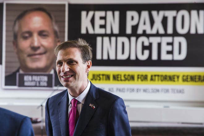 Justin Nelson, Democratic candidate for Texas attorney general, stands in front of a mobile billboard displaying the mugshot of Attorney General Ken Paxton in Austin on Monday. [Amanda Voisard/AMERICAN-STATESMAN]