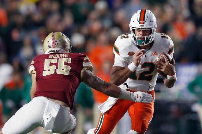 Miami quarterback Malik Rosier (12) tried to run past Boston College linebacker Isaiah McDuffie (55) during the first half of their game Friday night. [MICHAEL DWYER/Associated Press]