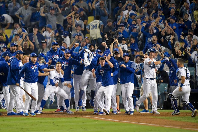 The Los Angeles Dodgers celebrates after Max Muncy's walk off during the 18th inning in Game 3 of the World Series baseball game against the Boston Red Sox on Saturday, Oct. 27, 2018, in Los Angeles. The Dodgers won 3-2. (AP Photo/Jae C. Hong)