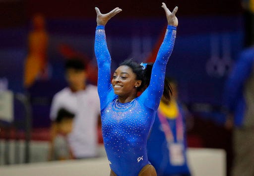 Simone Biles of the U.S. salutes fans after performing on the vault during qualifying sessions for the Gymnastics World Chamionships at the Aspire Dome in Doha, Qatar, Saturday, Oct. 27, 2018. A bout with a kidney stone did little to slow down Simone Biles, as he reigning Olympic champion easily posted the top all-around score of 60.965 during the early portions of qualifying at the 2018 world championships on Saturday, easily clearing the field and leaving little doubt that she remains atop the sport. (AP Photo/Vadim Ghirda)