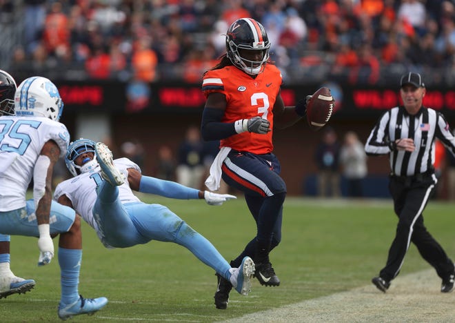 Virginia's quarterback Bryce Perkins runs out of bounds as North Carolina's Myles Dorn is hit on a block during the second half on Saturday in Charlottesville, Va. Virginia beat North Carolina 31-21. [Zack Wajsgras /The Daily Progress via AP]