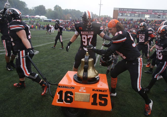 Massillon's Nakoa Keefer rings the Victory Bell as teammate Justin Gaddis pulls it across the field following Saturday's win over McKinley. (IndeOnline.com / Kevin Whitlock)
