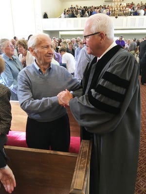 The Rev. John "Mike" Loudon talks with church member Chuck Bovay of Lakeland during Loudon's retirement service Sunday. Bovay and his wife, Connie, have been members of the church since 1956. [PAUL CATALA/THE LEDGER]