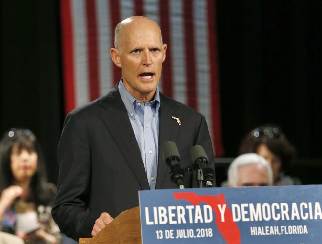 Florida Gov. Rick Scott speaks to Cuban-American supporters at a campaign stop in July. Recent financial disclosures required by Scott's bid for the U.S. Senate have raised questions about whether he has enriched himself by decisions he's made as governor. (AP Photo/Wilfredo Lee, File)