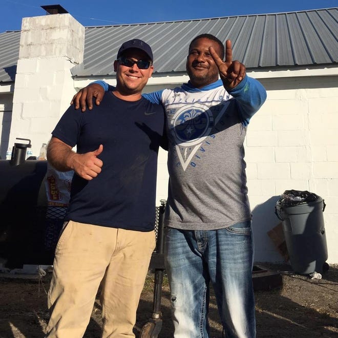 Kyle Swift stands with Eugene Brown, a Marianna local that has cooked nearly 1,000 meals a day for members of his community since the storm. [CONTRIBUTED PHOTO]