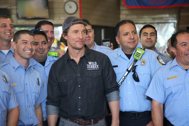 This Oct. 28, 2018 photo shows actor Matthew McConaughey posing with first responders in Houston as he surprised them with catered lunches. McConaughey said he wanted to celebrate National First ResponderþÄôs Day by giving thanks to the responders who risked their lives during Hurricane Harvey. (AP Photo/John Mone)