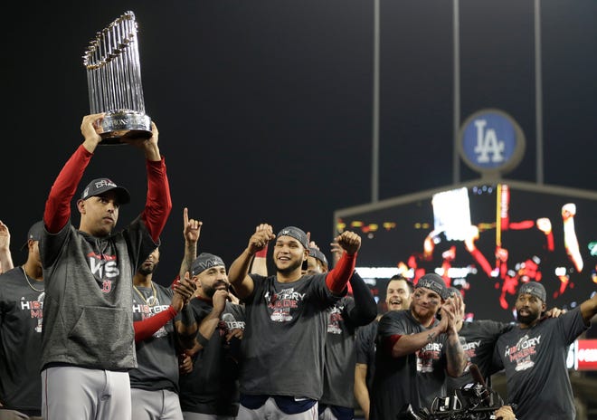 Boston Red Sox manager Alex Cora holds the championship trophy after Game 5 of baseball's World Series against the Los Angeles Dodgers on Sunday, Oct. 28, 2018, in Los Angeles. The Red Sox won 5-1 to win the series 4 game to 1.