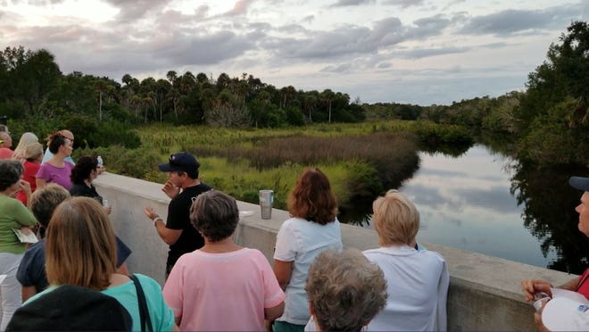 Chad Truxall, executive director of the Marine Discovery Center in New Smyrna Beach, speaks to a group about the Turnbull Creek's health and flora on a pedestrian bridge that runs from Holland Park in the west, through a 150-acre property the city aims to purchase if voters approve a preservation bond November 6. [News-Journal/Casmira Harrison]