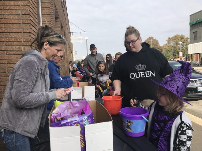 Workers at Brickey Printing hand out candy to Summer Lynn Charron, 5, along with her mom Rebecca Saturday in Lincoln. [Photo by Jean Ann Miller/The Courier]