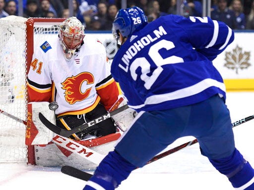 Calgary Flames goaltender Mike Smith (41) makes a save against Toronto Maple Leafs centre Par Lindholm (26) during first period NHL hockey action in Toronto on Monday, Oct. 29, 2018. (Nathan Denette/The Canadian Press via AP)