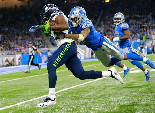 Detroit Lions cornerback Teez Tabor, right, pulls down Seattle Seahawks wide receiver David Moore during the second half of an NFL football game, Sunday, Oct. 28, 2018, in Detroit. (AP Photo/Rey Del Rio)