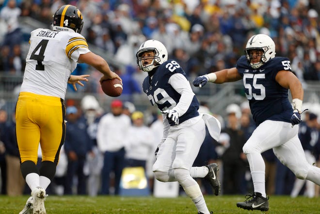 Penn State's John Reid (29) and Antonio Shelton (55) chase down Iowa quarterback Nate Stanley in the first half of last Saturday's game. [Chris Knight/The Associated Press]