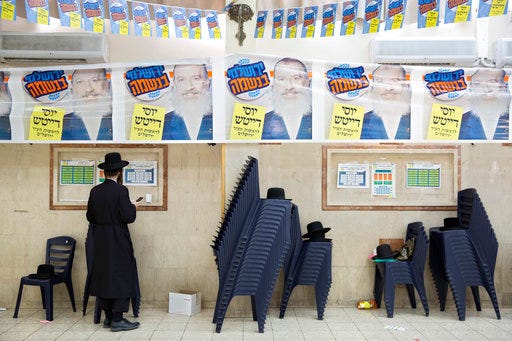 An Ultra-Orthodox Jewish man stands at the headquarter of of municipal candidate Yossi Daitch during the municipal elections in Jerusalem, Tuesday, Oct. 30, 2018. Israelis are voting in for municipal elections across the country. In the closest watched race Tuesday, four candidates are hoping to become the next mayor of Jerusalem. Posters read in Hebrew; "Yossi Daitch, Jerusalemite at heart". (AP Photo/Oded Balilty)