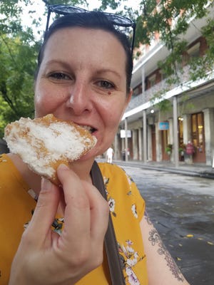 Epicuriosity columnist Jolene Lamb enjoys a beignet from Cafe du Monde in New Orleans, La. [Photo courtesy of Jolene Lamb]