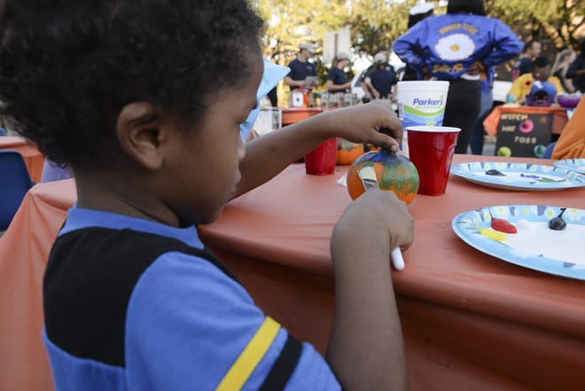 Emmanuel Lopez, 4, paints a pumpkin at Savannah police's second annual Pumpkin Painting with Police event on Tuesday. [Will Peebles/Savannahnow.com]