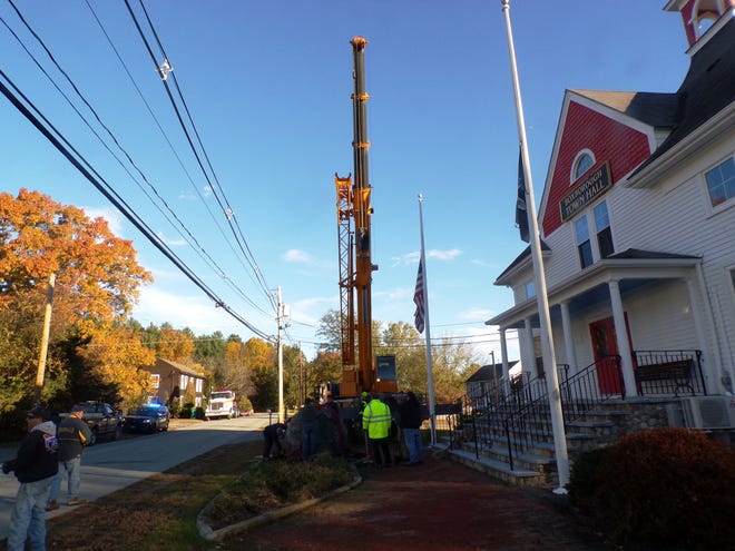 An Astro Crane crane looms over the Boxborough Town Hall, Tuesday morning as DPW and local business workers get ready to move the 8-ton WWI memorial to the Sargent Memorial Library. [Wicked Local Photo/Matt Mallio]