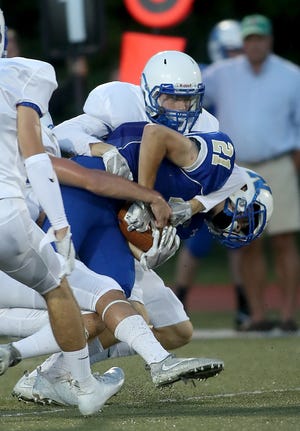 Norwell's Bobby Foley is brought down by Scituate's Garrett McKinnon during first-quarter action of their game at Scituate High on Friday, Sept. 7, 2018. [Wicked Local Staff Photo/ Robin Chan]
