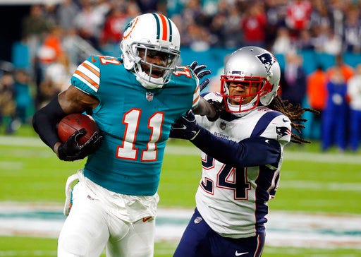 FILE - In this Monday, Dec. 11, 2017 file photo, New England Patriots cornerback Stephon Gilmore (24) attempts to tackle Miami Dolphins wide receiver DeVante Parker (11), during the first half of an NFL football game in Miami Gardens, Fla. he Miami Dolphins decided not to trade injury-prone receiver DeVante Parker, who is coming off perhaps the best game of his career and is eager to show he can stay healthy. (AP Photo/Wilfredo Lee, File)