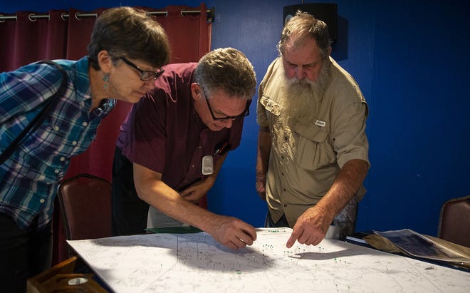Lewis Sharpe, right, helps Andrew and Mary Wier identify the location of their well during a meeting in Bastrop on Sept. 13. "We live off of our well, municipal water services don't reach us," Andrew Wier said. "We don't have a choice." The meeting allowed environmental activists and landowners to strategize against a permit application that would allow the LCRA to pump over 8 billion gallons of groundwater per year. [NICK WAGNER / AMERICAN-STATESMAN]