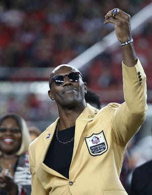 Former NFL wide receiver Terrell Owens holds up his Pro Football Hall of Fame ring during halftime of a game between the 49ers and the Raiders on Thursday. [Ben Margot/Associated Press]