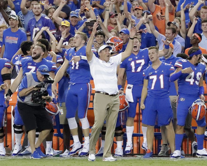 Florida head coach Dan Mullen, center, celebrates with players on the sidelines during the final moments of a game against LSU on Oct. 6 in Gainesville [AP Photo/John Raoux, File]