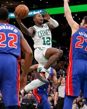 Boston Celtics guard Terry Rozier (12) drives to the basket between Detroit Pistons' Glenn Robinson III (22) and Zaza Pachulia during the first half of an NBA basketball game, Tuesday, Oct. 30, 2018, in Boston. (AP Photo/Mary Schwalm)