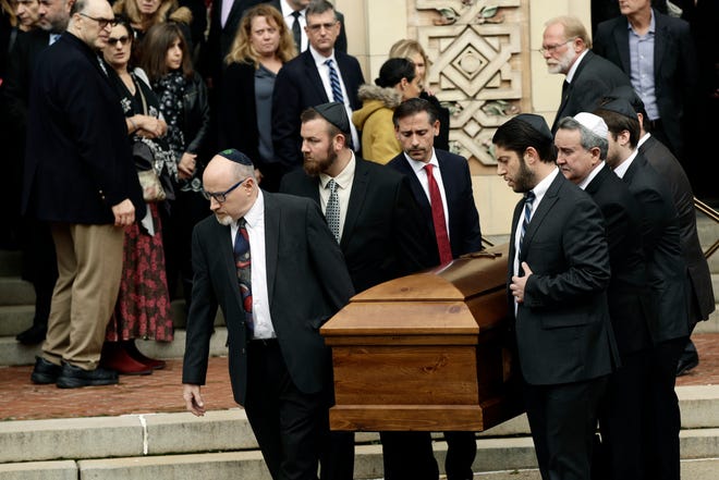 FILE - In this Oct. 30, 2018, file photo, a casket is carried out of Rodef Shalom Congregation after the funeral services for brothers Cecil and David Rosenthal, in Pittsburgh. The brothers were killed in the mass shooting last week at the Tree of Life synagogue. A team of rabbis and volunteers has gone into the Tree of Life synagogue to gather up blood and other remains from the victims of the shooting rampage, in keeping with Jewish law that says the entire body must be buried. (AP Photo/Matt Rourke, File)