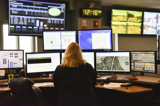 FILE- In this March 15, 2018, file photo a dispatcher works at a desk station with a variety of screens used by those who take 911 emergency calls in Roswell, Ga. The Roswell call center is one of the few in the United States that accepts text messages. Most places in the U.S. donþÄôt have access to text-to-911 services, an increasingly crucial gap during an era of mass shootings and other catastrophes, when a phone call is not always an option. (AP Photo/Lisa Marie Pane, File)