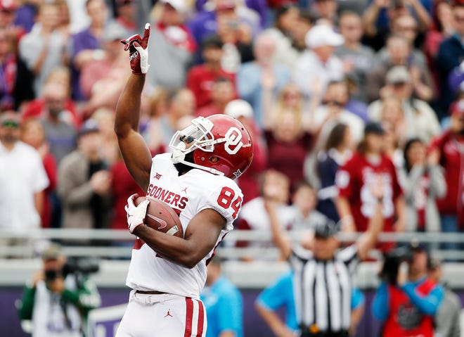 FILE - In this Saturday, Oct. 20, 2018, file photo, Oklahoma wide receiver Lee Morris (84) points skyward after scoring a touchdown during the first half of an NCAA college football game against TCU in Fort Worth, Texas. Oklahoma receiver Lee Morris and Oklahoma State quarterback Taylor Cornelius are among the top players in the nation who started their careers as walk-ons. (AP Photo/Brandon Wade, File)