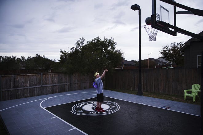 Cash Samarron, 12, who was diagnosed with Ewing sarcoma, was given a basketball court by the Make-A-Wish Foundation. Cash plays on his new court at his home in Liberty Hill on Wednesday. [Amanda Voisard/AMERICAN-STATESMAN]