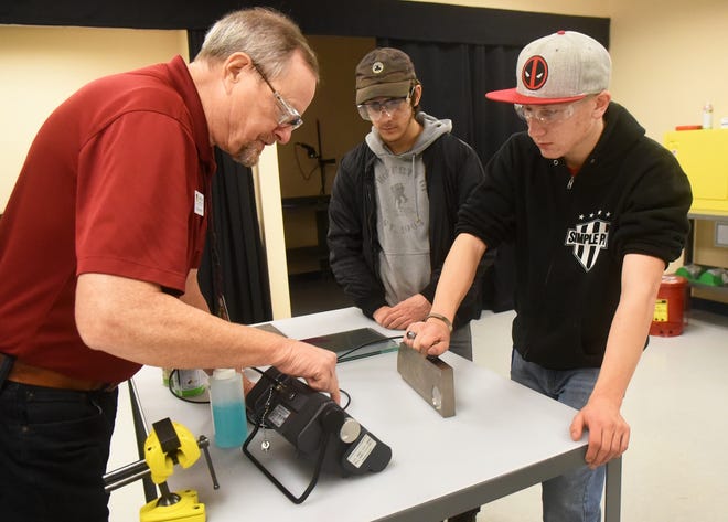 Students Curtis Kimball, left, and Dylan Dibernardo listen to a Great Bay instructor in the Non-Destructive Testing lab during class Friday. [Deb Cram/Fosters.com]