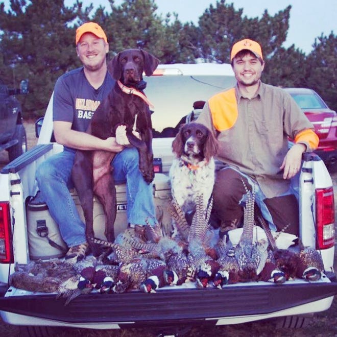 Former state Sen. Garrett Love, right, runs Western Kansas Pheasant Hunting at his family farm near Montezuma. He and one of his guides, Chayne Onek, pose for a photo with some pheasants and their bird dogs RJ and Bella after a hunt. Onek is also Love's brother-in-law. [Submitted]