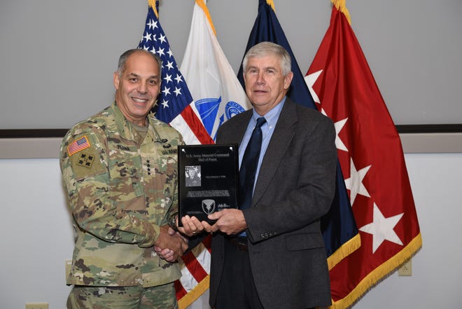 Army Materiel Command commander Gen. Gus Perna presents a plaque to retired Gen. Benjamin Griffin during his induction into the Army Materiel Command Hall of Fame on Oct. 24. [Kari Hawkins/U.S. Army]