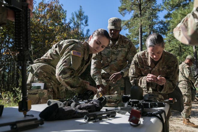 Candidates seeking the Expert Field Medical Badge disassemble and reassemble an M4 rifle as quickly as possible during the standardization phase of EFMB testing Oct. 30 on Fort Bragg. [Spc. Liem Huynh/U.S. Army]
