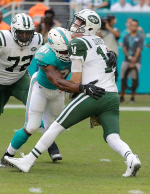 Miami's Cameron Wake (91) sacks New York's Sam Darnold (14) during the first half Sunday in Miami Gardens. At left is the Jets' Brandon Shell. [Associated Press/Lynne Sladky]