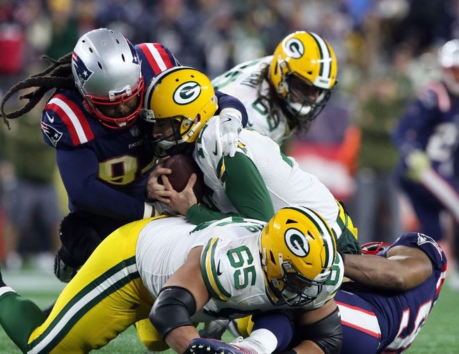 New England's Adrian Clayborn sacks Packers quarterback Aaron Rodgers in the fourth quarter with help from Trey Flowers, right.