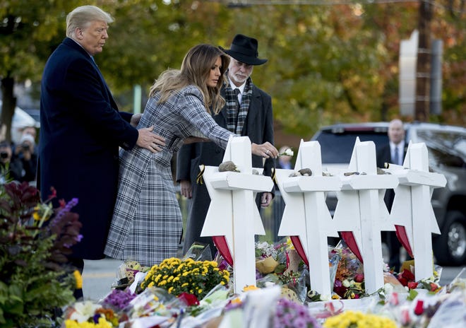 First lady Melania Trump, accompanied by President Donald Trump, and Tree of Life Rabbi Jeffrey Myers, right, puts down a white flower Oct. 30 at a memorial for those killed at the Tree of Life Synagogue in Pittsburgh. [AP Photo/Andrew Harnik]