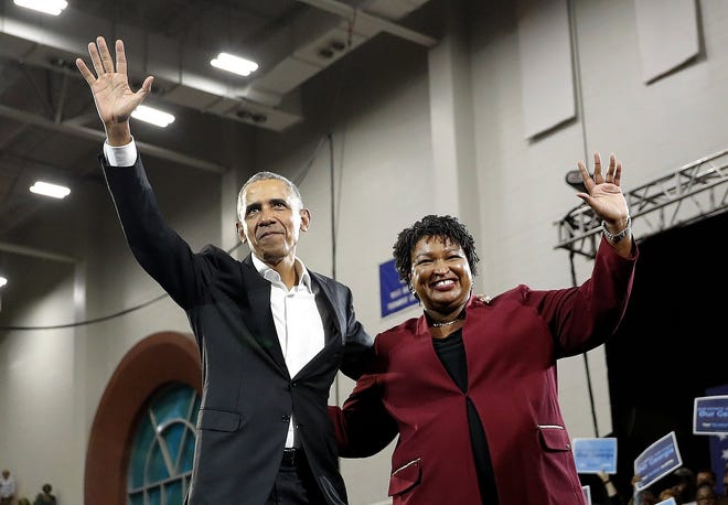 Former President Barack Obama and Georgia's Democratic candidate for governor, Stacey Abrams, wave to the crowd during a campaign rally at Morehouse College Friday in Atlanta. Abrams said Sunday that Democrats had made no attempt to hack into the state's voter records. [John Bazemore/The Associated Press]