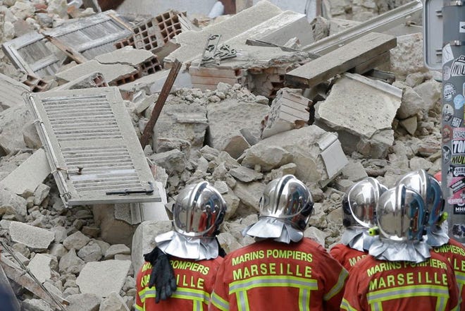 Firefighters work at the scene where a building collapsed In Marseille, southern France, Monday, Nov. 5, 2018. A building collapsed in the southern city of Marseille on Monday, leaving a giant pile of rubble and beams. There was no immediate word on any casualties. (AP Photo/Claude Paris)
