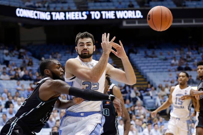 North Carolina's Luke Maye (32) loses the ball while Mount Olive's Cameron Robinson defends during the first half of a college basketball exhibition game in Chapel Hill, N.C., Friday, Nov. 2, 2018. (AP Photo/Gerry Broome)