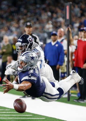 Dallas Cowboys quarterback Dak Prescott (4) reaches for the ball as Tennessee Titans linebacker Wesley Woodyard defends in the second half. [Ron Jenkins/The Associated Press]