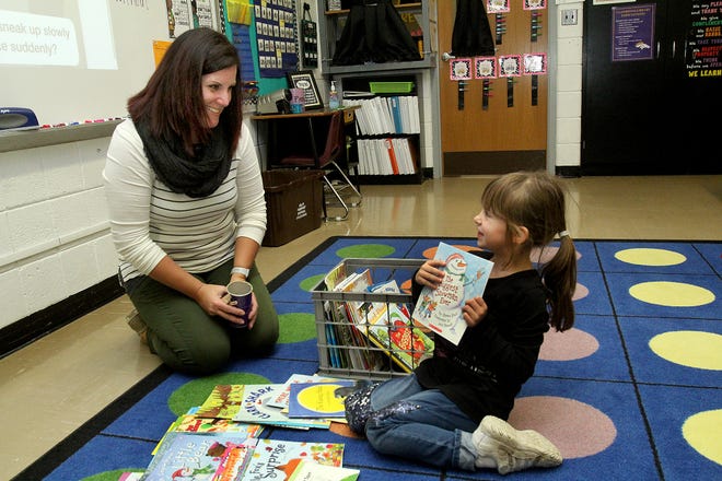 Teacher Julie Cahoon-Jackson interacts with Montanna Webb, a first-grader, as she selects a book Tuesday, Oct. 23, 2018, at Orangeville Grade School. [JANE LETHLEAN/THE JOURNAL-STANDARD CORRESPONDENT]