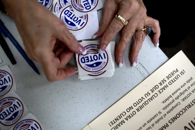 A poll worker gets "I Voted" stickers ready to hand to voters in South Tampa. [FILE PHOTO]