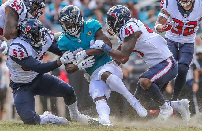 Jacksonville Jaguars running back T.J. Yeldon (24) is tackled by Texans defenders. The Jaguars' Nov. 18 game against the Steelers was moved out of prime time with the Jags mired in a four-game losing skid. [For The Florida Times-Union/Gary Lloyd McCullough]